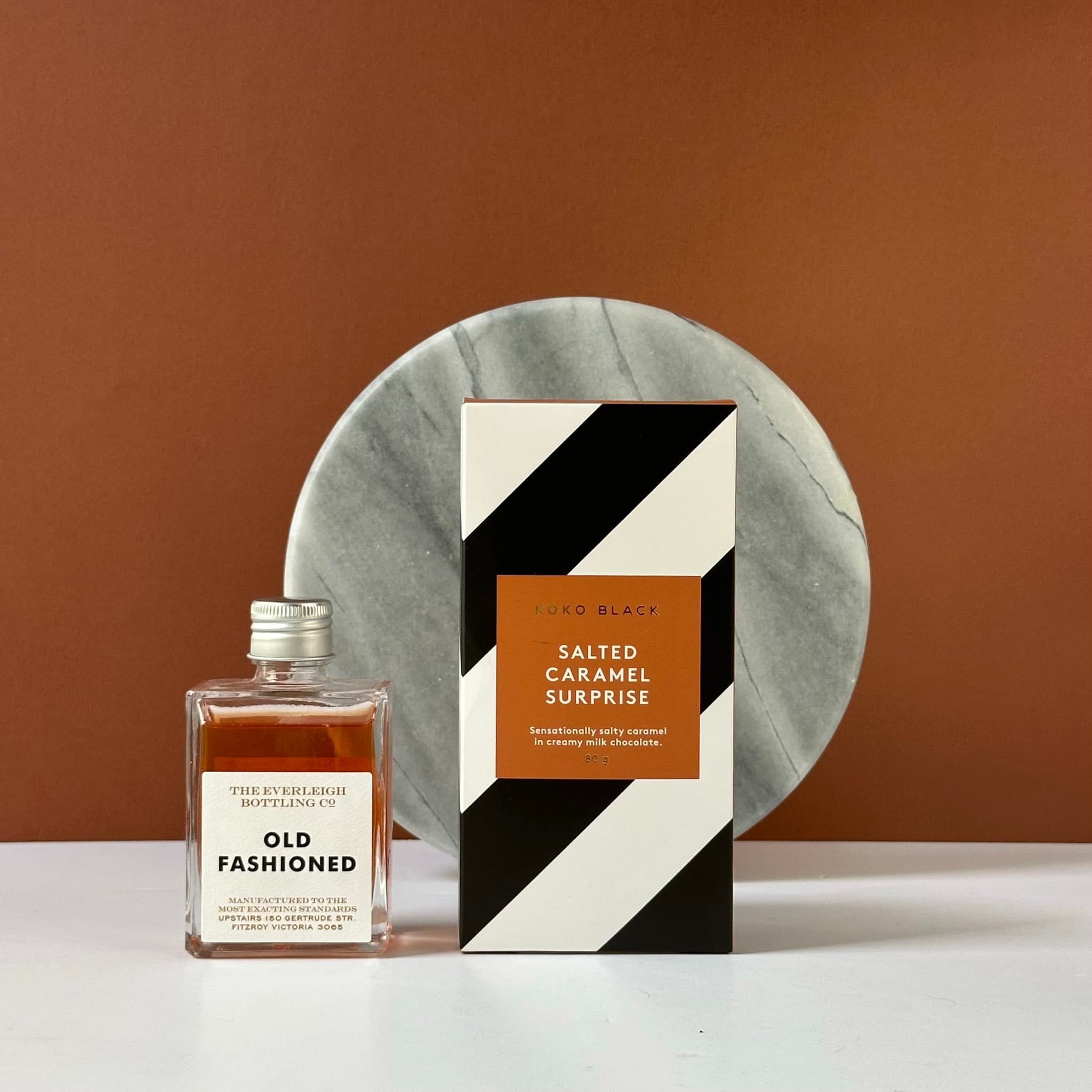 A sophisticated gift bundle featuring The Everleigh Bottling Co. Old Fashioned and Koko Black Salted Caramel Surprise chocolates, beautifully packaged in a premium Thankly black box.