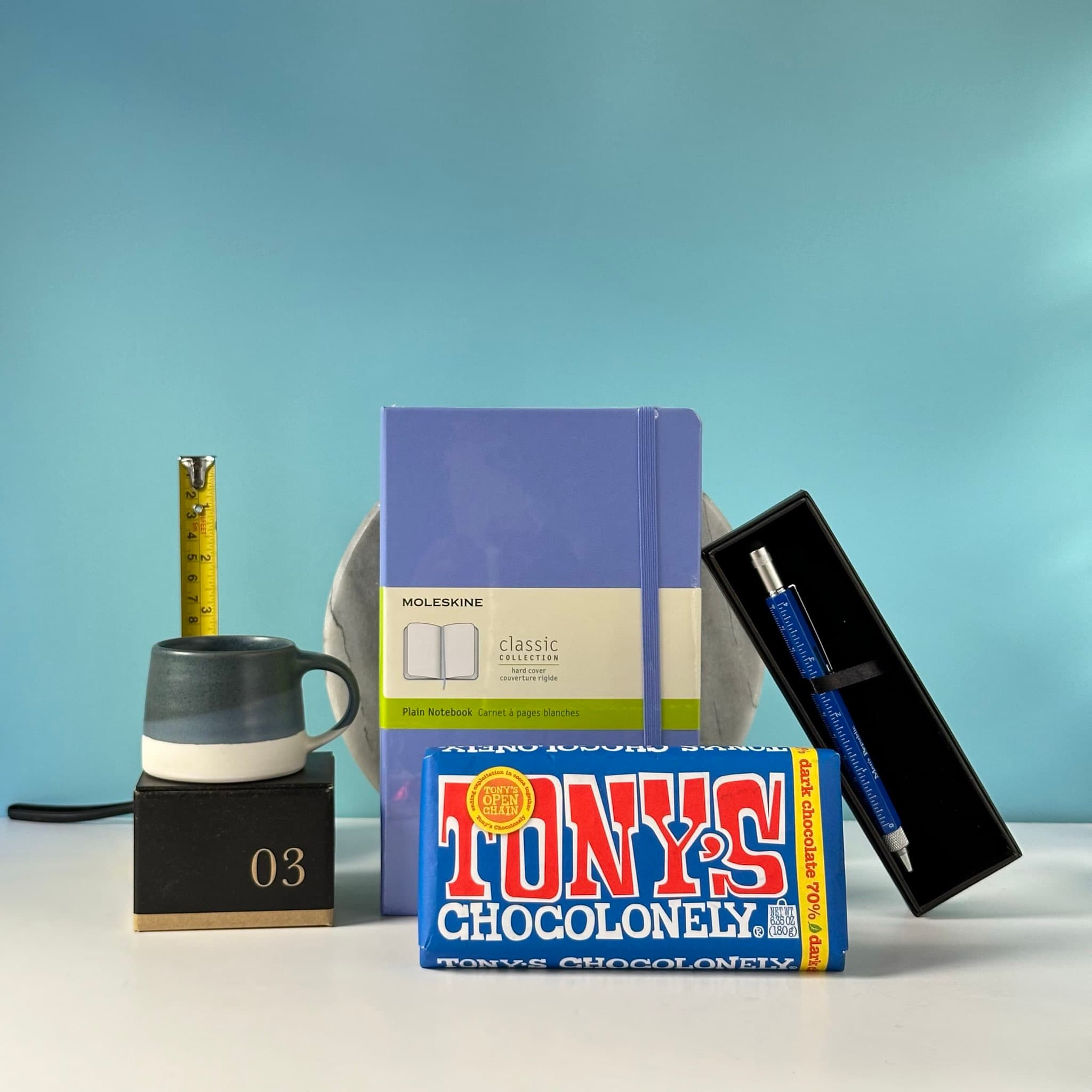 The Overthinker gift set with a Moleskine notebook, multi-tool pen, espresso cup, dark chocolate, and handwritten Thankly card in a black box.