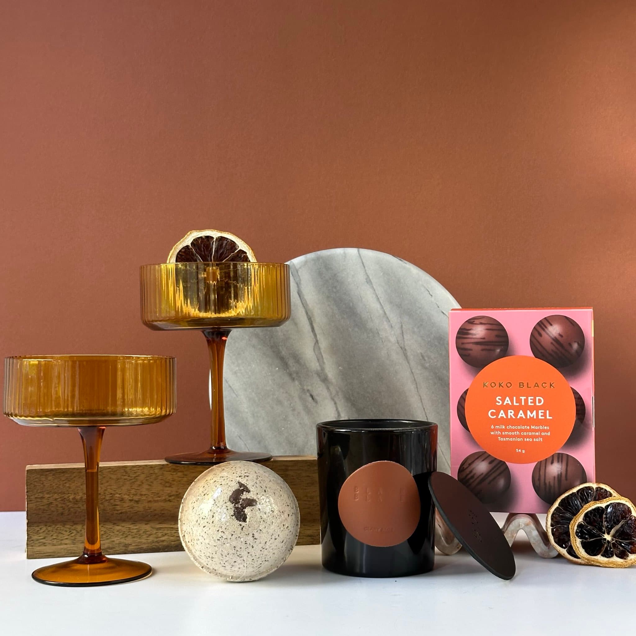 The Perfect Couple gift set with coupe glasses, scented candle, bath bomb, salted caramel treats, and a handwritten Thankly card in a premium black box.
